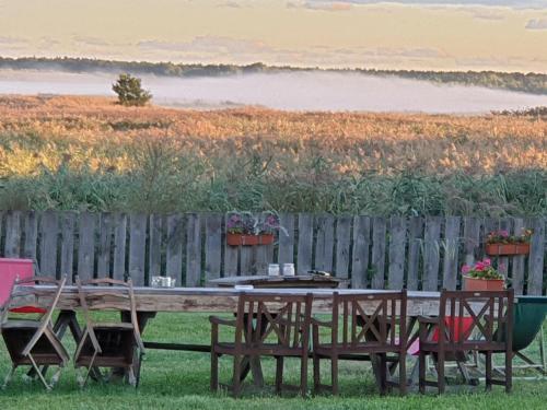 a wooden table with chairs and a fence at DOM GOŚCINNY PTASZARNIA - NATURA-Free PARKING in Świnoujście