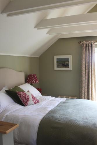 ein Schlafzimmer mit einem weißen Bett und einem Fenster in der Unterkunft The Green Room in Midhurst