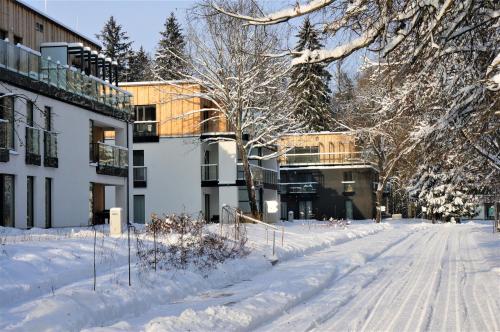 a snow covered street in front of a building at Enklawa Białowieska Forest & Spa in Hajnówka