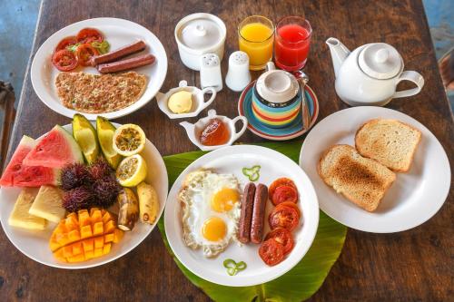 a table with plates of breakfast food on it at Zanzi Rest Bungalow in Nungwi