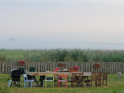 a wooden table and chairs in front of a fence at DOM GOŚCINNY PTASZARNIA - NATURA-Free PARKING in Świnoujście