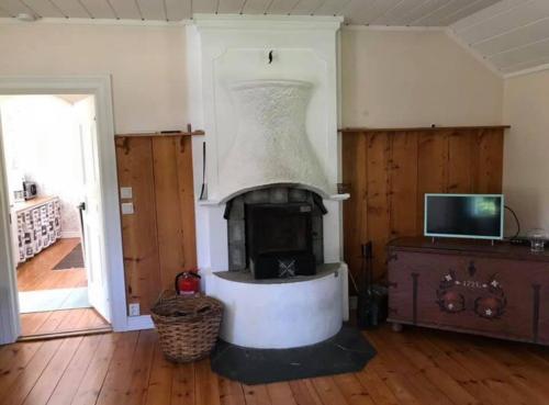 a living room with a fireplace in a house at Källåsens Stuguthyrning in Sjötofta