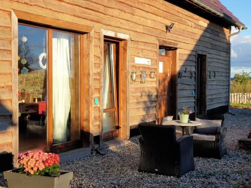 a cabin with chairs and a table and a patio at DOM GOŚCINNY PTASZARNIA - NATURA-Free PARKING in Świnoujście