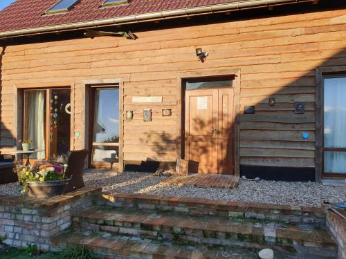 a wooden house with a door and stairs in front at DOM GOŚCINNY PTASZARNIA - NATURA-Free PARKING in Świnoujście