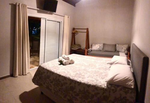 a bedroom with a bed with a teddy bear on it at Pousada Bezerra in Nazaré Paulista
