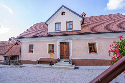 una casa con un banco delante de ella en Notranjska hiša - traditional country house, close to the world attraction Cerknica lake, en Begunje pri Cerknici