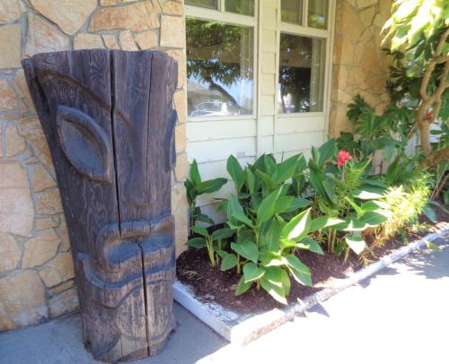 a totem pole outside of a house with plants at The Polynesian Resort in Ocean Shores