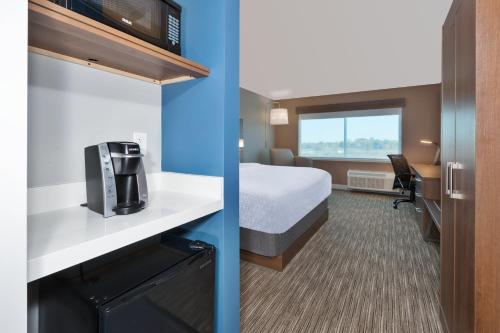 a hotel room with a bed and a tv at Holiday Inn Express & Suites - Cedar Springs - Grand Rapids N by IHG in Cedar Springs
