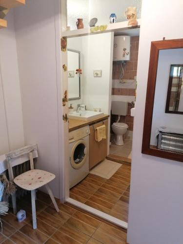 a bathroom with a washing machine and a sink at Holiday home Mrežnički šum in Generalski Stol