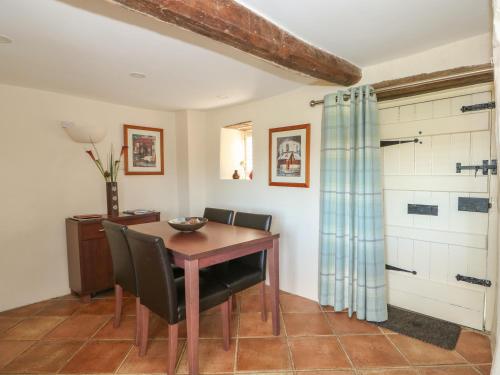 a dining room with a wooden table and chairs at Bumble Bee in Oakham