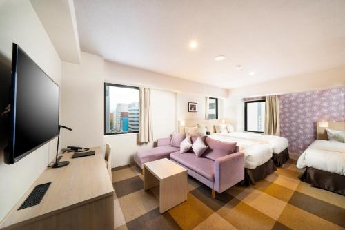 a hotel room with a bed and a tv at KOKO HOTEL Sapporo Odori in Sapporo