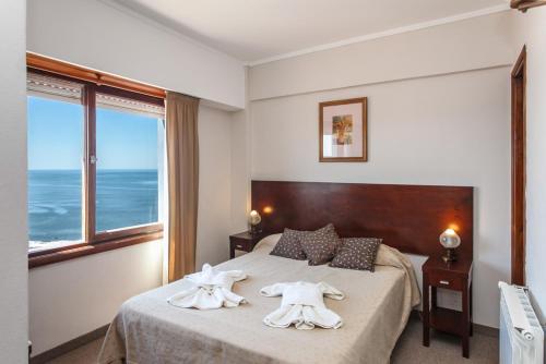 una habitación de hotel con una cama con toallas en el Apart Hotel Torre Del Sol de Villa Gesell