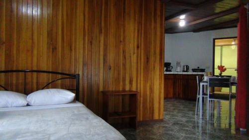 1 dormitorio con 1 cama y cocina con mesa en Monteverde Family House en Monteverde Costa Rica