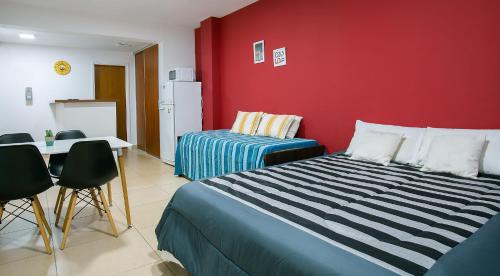 a bedroom with a bed and a red wall at Happy Guest Apart 36 in Ushuaia