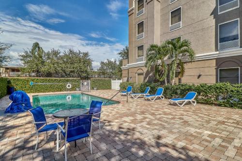 a patio with chairs and a table and a pool at Holiday Inn Express Hotel & Suites Clearwater US 19 North by IHG in Clearwater