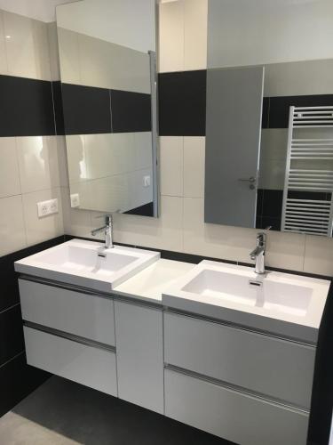une salle de bain avec deux lavabos et un grand miroir dans l'établissement Villa Tinuta 8 pers piscine chauffée 5 min plage en voiture, à Sainte-Lucie de Porto-Vecchio
