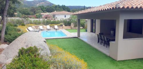une cour arrière avec une piscine et une maison dans l'établissement Villa Tinuta 8 pers piscine chauffée 5 min plage en voiture, à Sainte-Lucie de Porto-Vecchio