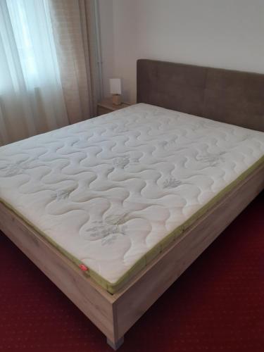 a bed in a bedroom with a white mattress at Casa Azugeana in Azuga