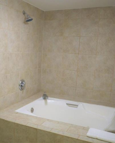 a bath tub in a bathroom with a shower at Baymont by Wyndham Norcross Atlanta in Norcross