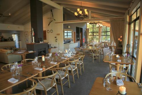 uma sala de jantar com mesas e cadeiras de madeira em Punga Cove Resort em Endeavour Inlet