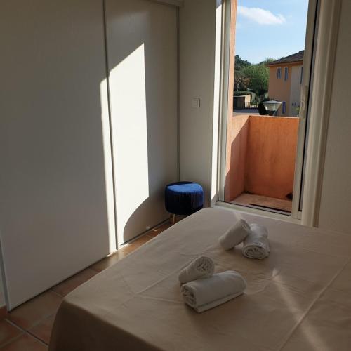 - un lit avec des serviettes et une grande fenêtre dans l'établissement Mini villa Messicana 5 pers piscine 500 m plage, à Lecci