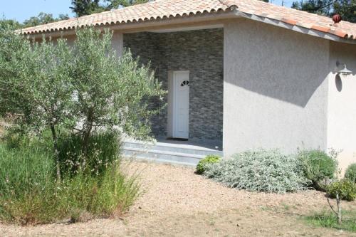 une petite maison blanche avec une porte blanche dans l'établissement Villa Salute 6 pers 5 min plage en voiture, à Porto-Vecchio