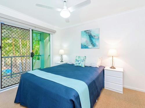 a bedroom with a blue bed and a window at Blue Pacific 2 in Yamba