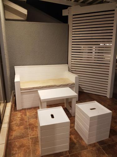 un banco blanco y dos taburetes en una habitación en Cabañas Vientos del Mar, en Pichilemu