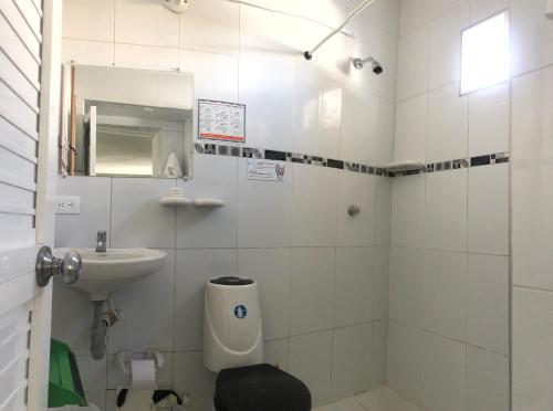 a white bathroom with a sink and a toilet at Edificio águila in San Andrés