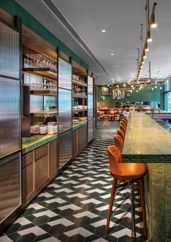 a restaurant with a long bar and chairs at The Hari Hong Kong in Hong Kong