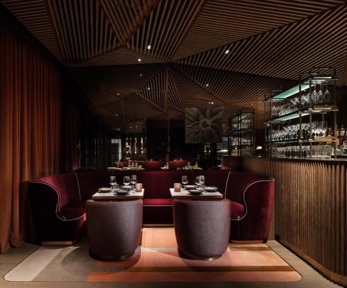 a restaurant with tables and chairs and a bar at The Hari Hong Kong in Hong Kong