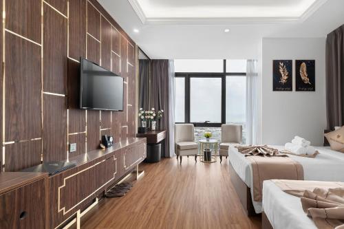 a hotel room with two beds and a flat screen tv at Thai Ha Boutique Hotel in Ha Long