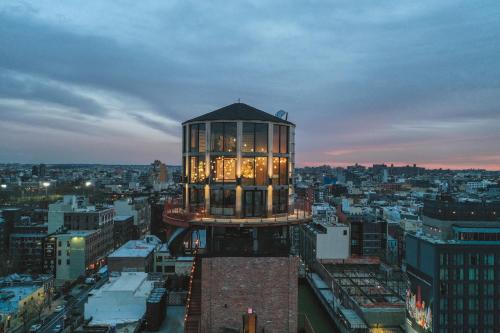 a building with lights on top of a city at The Williamsburg Hotel in Brooklyn