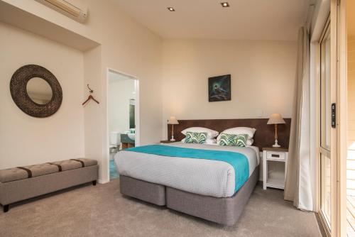 a bedroom with a large bed and a mirror at Punga Cove Resort in Endeavour Inlet