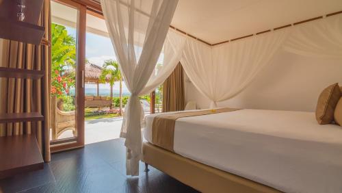 a bedroom with a bed and a view of the ocean at Villa Butterflydream in Karangasem