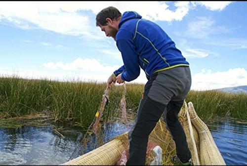 a man in the water with a net at Luz del Titicaca Lodge in Puno