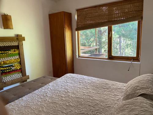 a bedroom with a bed and a window at Alto Curanipe in Pelluhue