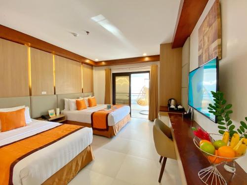 a hotel room with two beds and a flat screen tv at Jony's Beach Resort in Boracay
