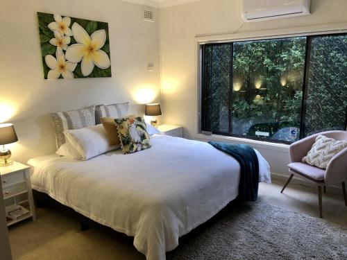 een slaapkamer met een groot bed en een raam bij Hotel Style Monterey Guest Studio near Hospitals, Beach and Airport in Sydney