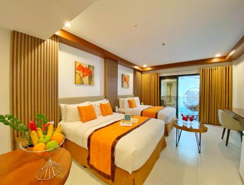 a hotel room with two beds and a bowl of fruit on a table at Jony's Beach Resort in Boracay