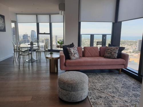 a living room with a couch and a table at Orange Stay at Melbourne Quarter in Melbourne