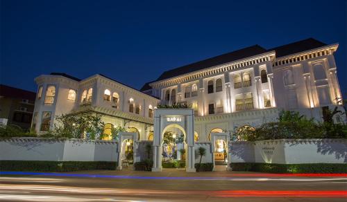 a large white building with lights on at night at Sarai Resort & Spa and The Wander in Siem Reap