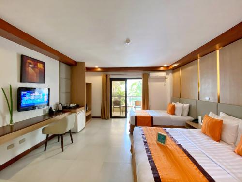a hotel room with two beds and a flat screen tv at Jony's Beach Resort in Boracay