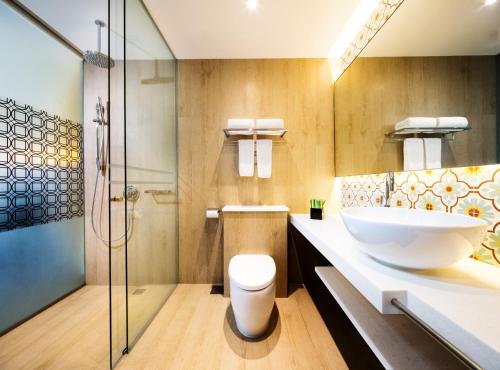 a bathroom with a sink and a glass shower at Village Hotel Katong by Far East Hospitality in Singapore