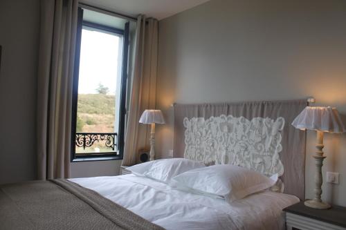 a bedroom with a white bed with a window at Villa Pen Prad in Sauzon