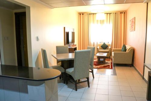 a room with a table and chairs and a living room at Spark Residence Hotel in Sharjah