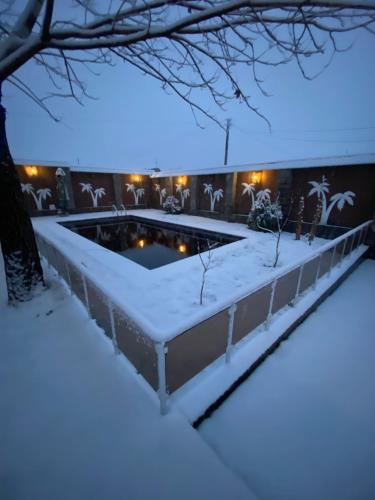 a swimming pool covered in snow at night at Qafqaz Fountain Villa in Gabala