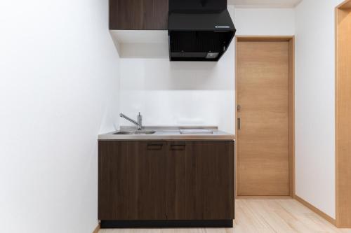 a kitchen with a sink next to a door at 大吉屋本館 ワンフロア貸切部屋 名駅離れ in Nagoya