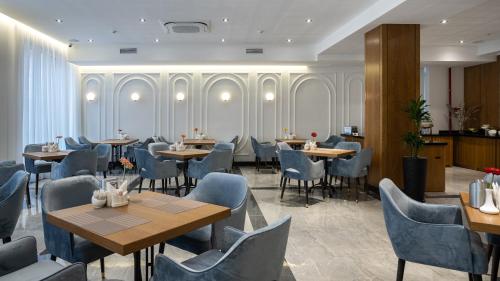 a restaurant with tables and chairs in a room at HOTEL MODERNO & Spa in Tashkent