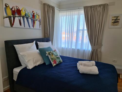 Un dormitorio con una cama azul con una toalla. en Harden Golfers Rest Accommodation, en Harden